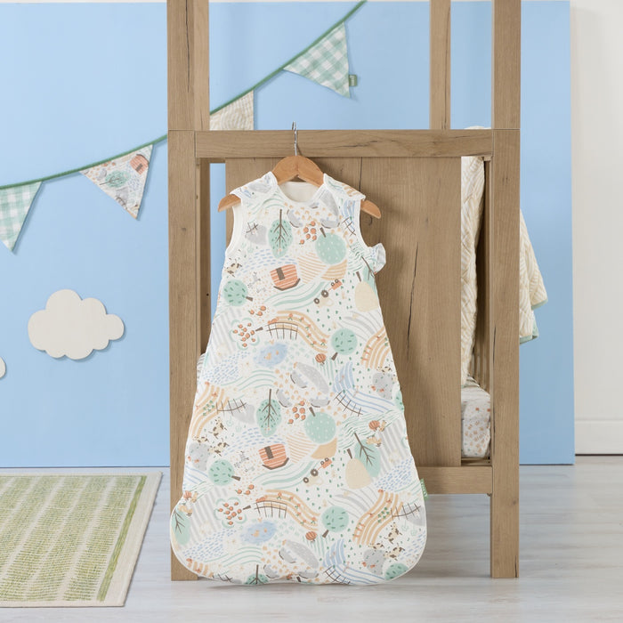 Good Life baby sleep bag hanging in a light nursery with blue wall and bunting, featuring calming farmyard print
