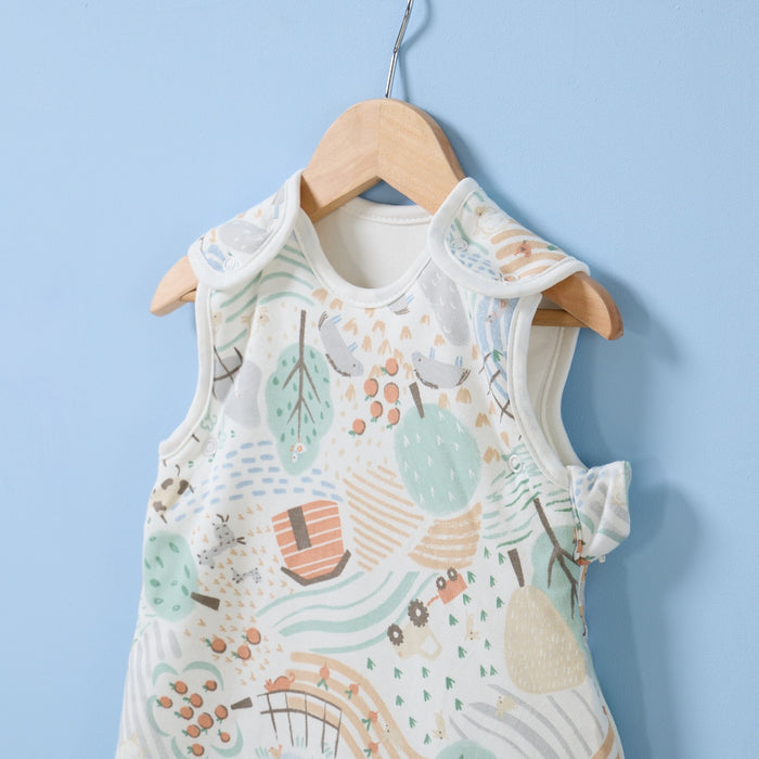Hanging close-up of Good Life baby sleep bag with shoulder poppers and playful countryside print in soft neutral tones.