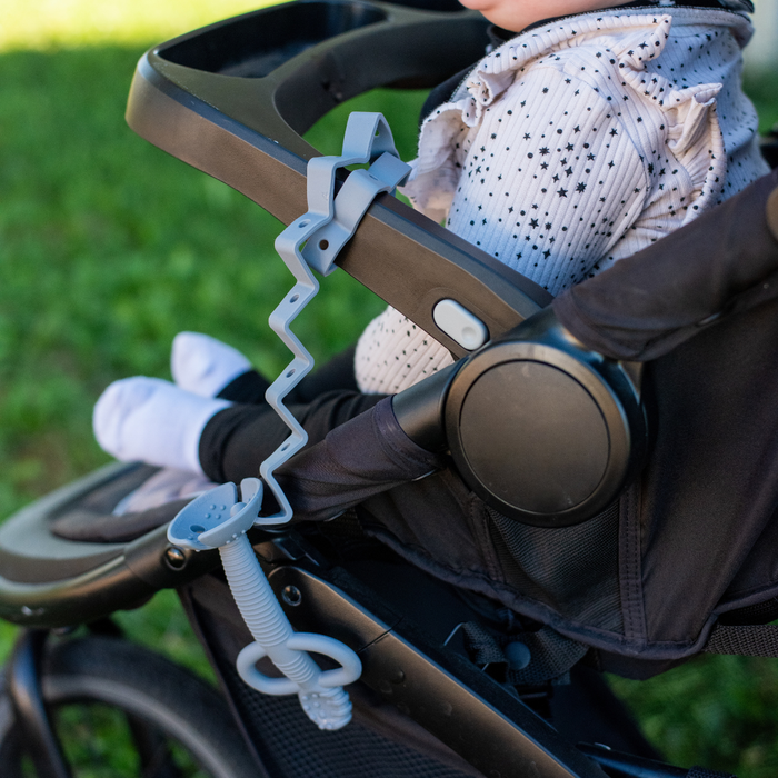 Busy Baby Teething Spoon attached to a stroller with the Busy Baby Toy Bungee