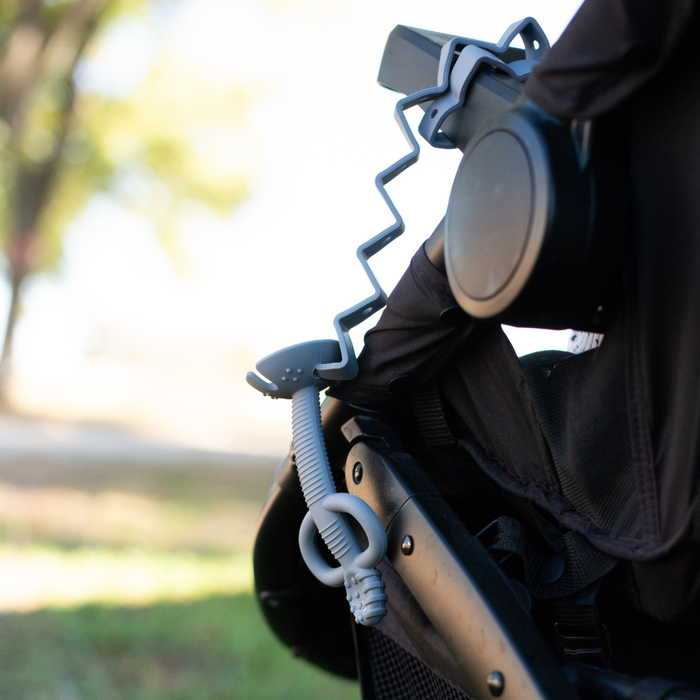 Busy Baby Teething Spoon attached to a stroller with a busy baby toy bungee