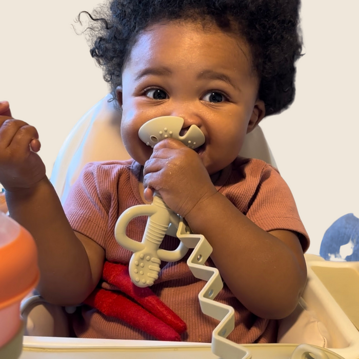 Baby chewing on Tan Busy Baby 2-in-1 Teether & Training Spoon