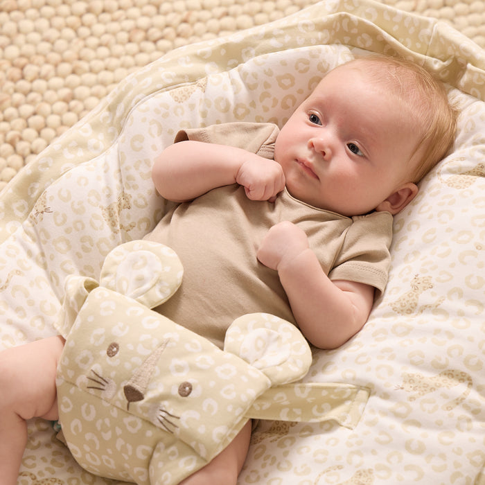 Baby lying on the Love Cats beanbag with safety harness, showing adorable embroidered cat face and cosy, supportive fit