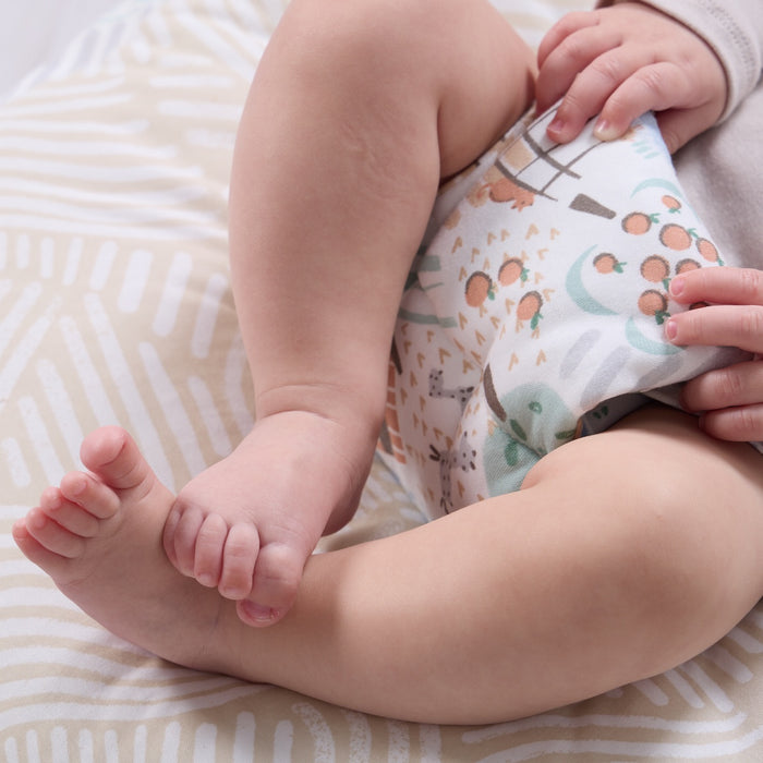 Close-up of baby’s legs resting on the Good Life beanbag, showing soft fabric texture and nature-inspired pattern detail