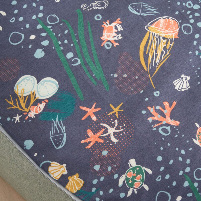 Fabric close-up of the Our Planet baby beanbag, showcasing the soft textured upholstery and playful ocean-inspired print on the seat