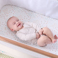 Baby lying in the CoZee next to me crib with the Good Life fitted sheet