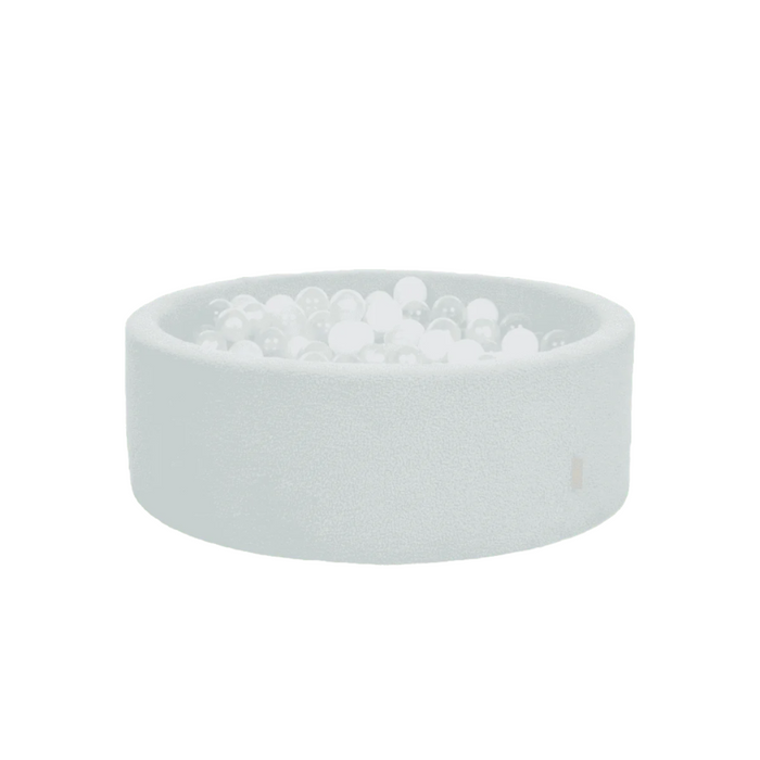 Cutout view of the Bola baby ball pit in sea mist, showcasing the soft boucle finish, circular shape, and white balls for gentle sensory play