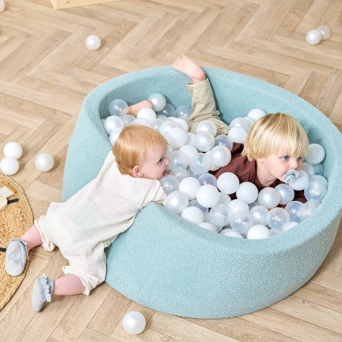 Bola Baby Ball Pit in Ocean Stone - lifestyle image of little boy and girl playing together in the ball pit