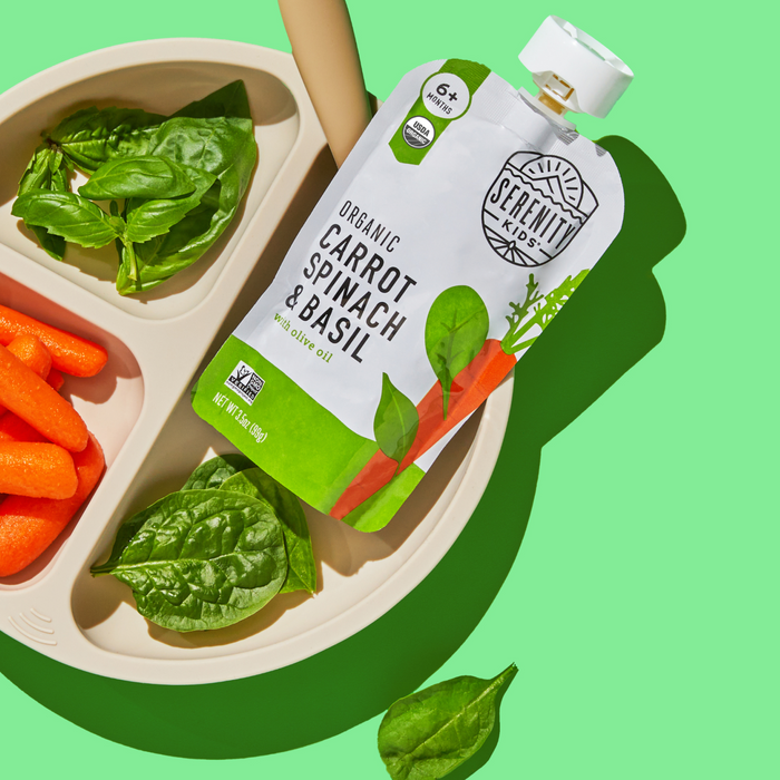 Serenity Kids organic carrot spinach basil pouch on a plate with green background