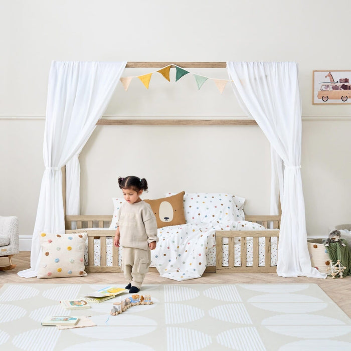 A girl standing next to the Casa Grande Toddler Bed Floor in a playful nursery