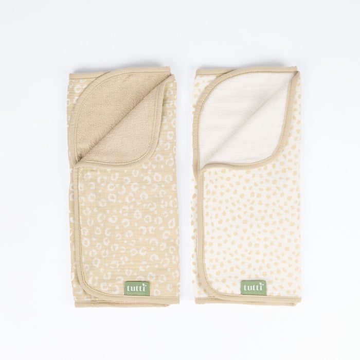 Cutout view of two changing mat liners featuring reversible leopard and spot prints in soft muslin fabric with absorbent towelling back