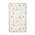 A beige changing mat with a woodland animal pattern including small illustrations of rabbits and leaves.