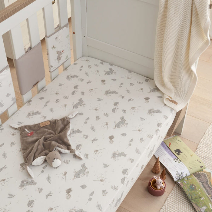 Lifestyle view of cot fitted sheet in Cocoon design with playful woodland animal prints, made from soft cotton for a snug and cosy nursery setting