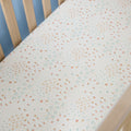 Farm-patterned cot bed sheet on a wooden cot with a light blue wall background