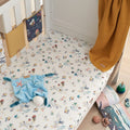 Lifestyle view of cot fitted sheet in Our Planet design, ocean-themed cotton fabric creating a snug, playful and calming nursery space