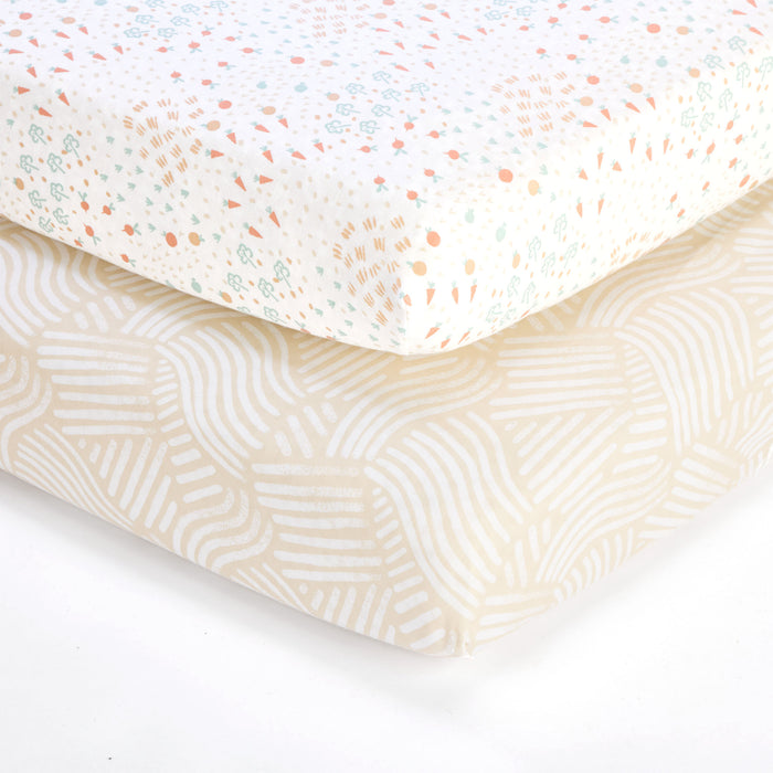 Cutout of Good Life cot fitted sheets 2 pack showing cream floral and beige wave designs, made from soft, breathable cotton for cosy sleep