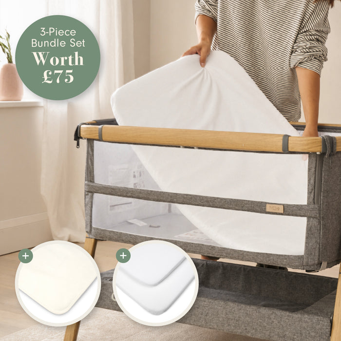 A 3-piece bundle set for a baby crib, shown in a lifestyle setting with a person adjusting the white mattress inside a grey and wood crib. Two circular inset graphics at the bottom show included bedding: a mattress protector and a white fitted sheet.