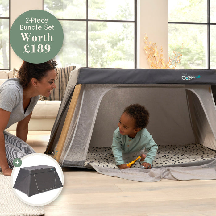 A child playing in a portable travel cot and playpen with a woman in a living room setting.