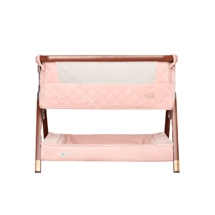 Front view of the CoZee Luxe Mini Me crib in walnut and blush, with breathable mesh panel and quilted detailing for stylish, secure sleep