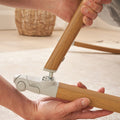 Close-up of CoZee rocking bar being assembled, showing secure attachment mechanism and walnut-effect wood grain with ecru detailing