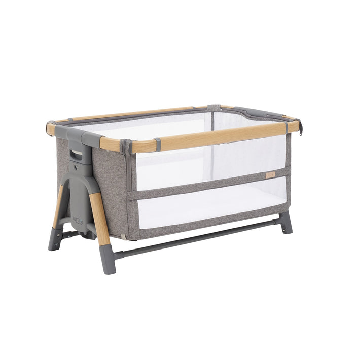 Cutout of the CoZee bassinet in oak and charcoal showing breathable mesh sides and compact frame in stationary mode