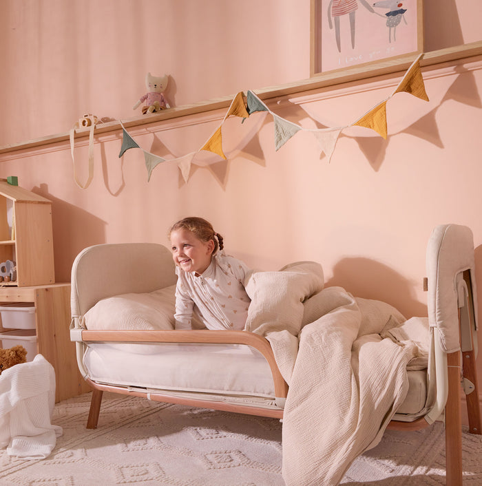 CoZee XL Scandi shown in junior bed mode with plush cushions and teddy, showing open side design for safe, independent toddler use