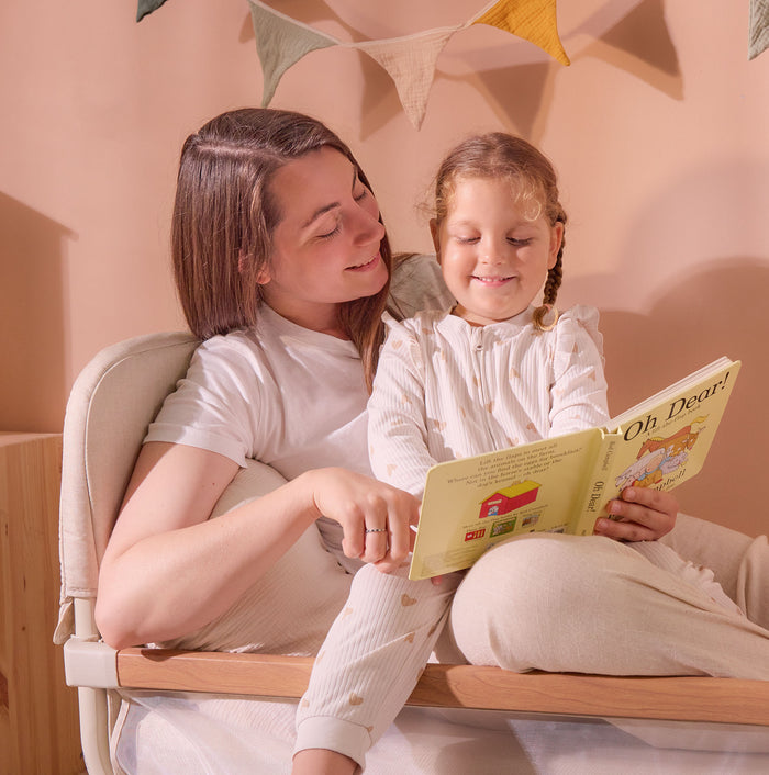 Mum and child reading on the CoZee XL Scandi junior bed, showing supportive side panel design and child-friendly transition from cot mode.