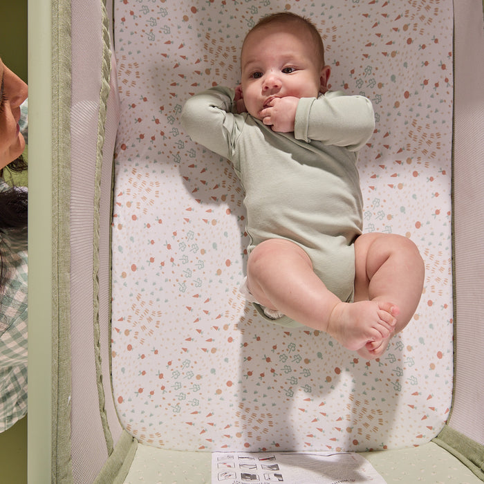 Overhead view of a baby resting comfortably inside the CoZee Zen bedside crib, highlighting the breathable mattress and soft interior fabrics.