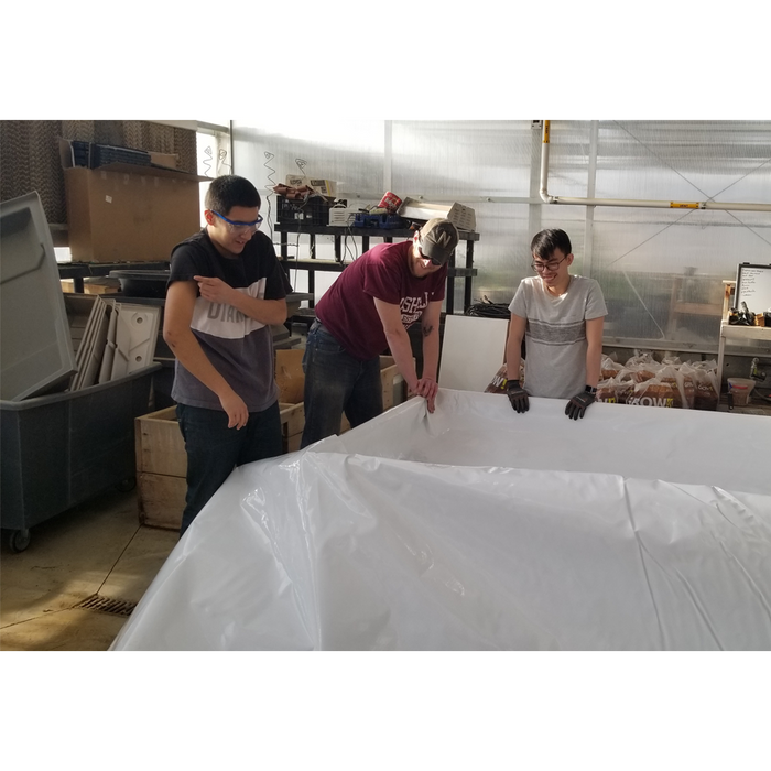 Three people standing around an Aquaponics For Life Dura-Skrim Liner – 12′ Width.
