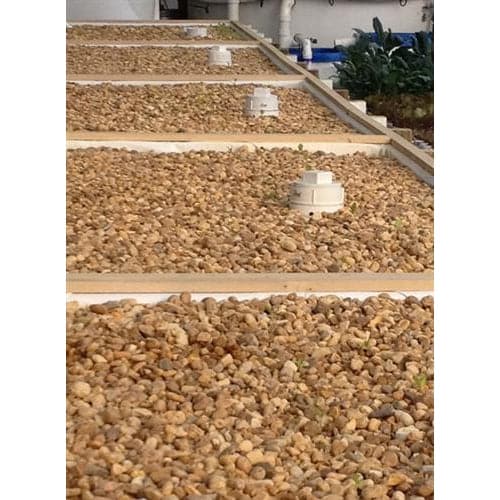 A durable row of Aquaponics For Life's Dura-Skrim Liner – 12' Width on top of a building.