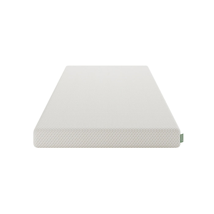 A white textured junior mattress layer shown at an angle on a solid white background, featuring a small green tag on the corner.
