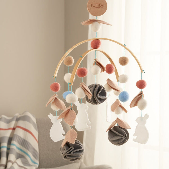 A decorative baby mobile with various felt animals and Embroidery appliques in a woodland theme, suspended from a bamboo frame.