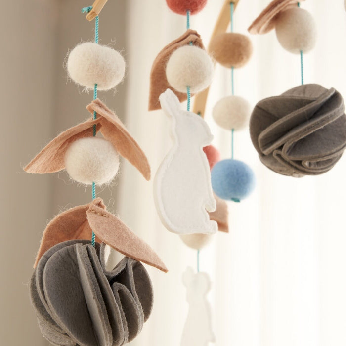Close-up of the Cocoon felt nursery mobile showing handcrafted felt elements and gentle colour palette for visual stimulation
