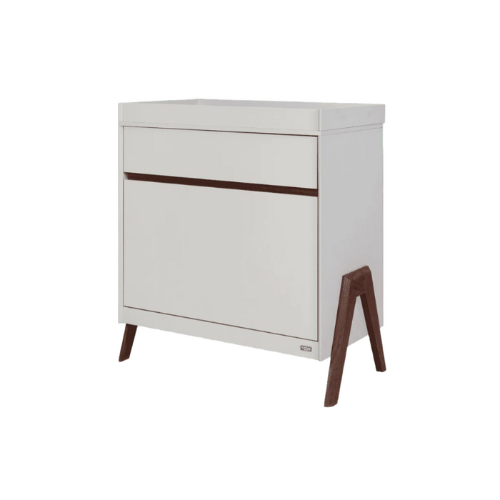 Angled cutout view of the Fuori chest changer in white sand and warm walnut, highlighting its modern silhouette, sturdy legs, and minimalist design