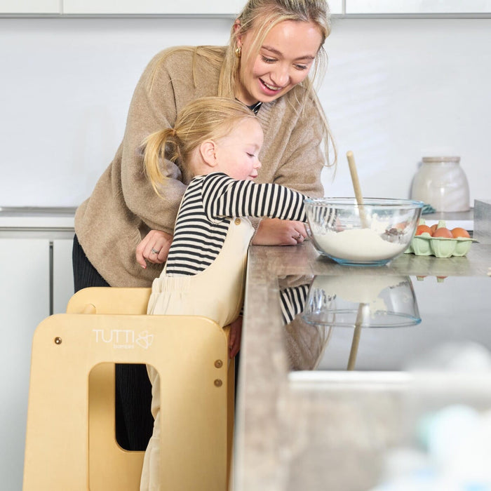 Close-up of mum and toddler at the kitchen counter with the Helping Hands Montessori learning tower in natural finish, encouraging hands-on learning.
