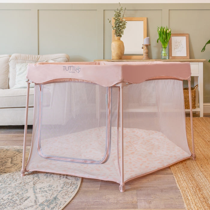 Hexa Playpen in Gumdrop Terrazzo set up in a living room, with soft mesh sides, curved zip opening, and terrazzo-print padded floor