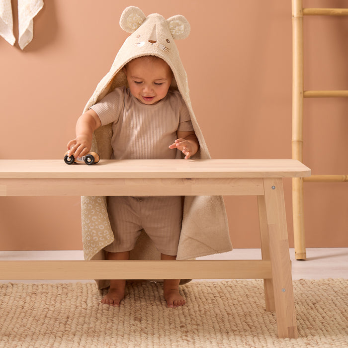 Toddler playing with toy car while wearing the Luca Leopard hooded towel in soft beige terry, lined with subtle leopard print cotton
