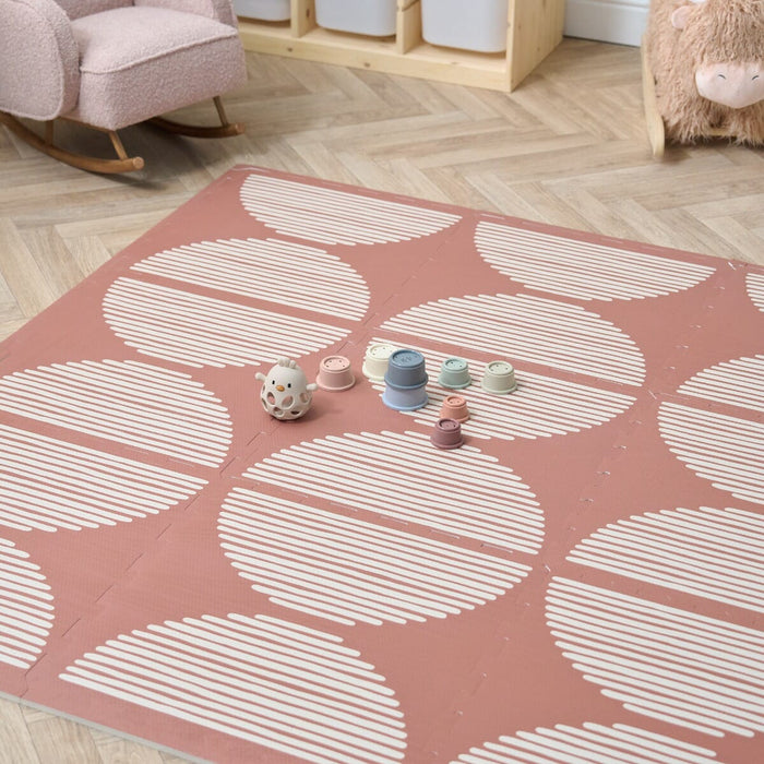 The Orbital Nutmeg Baby Infinity Playmat on a playroom with a mini rocking chair and a rocking animal toy.
