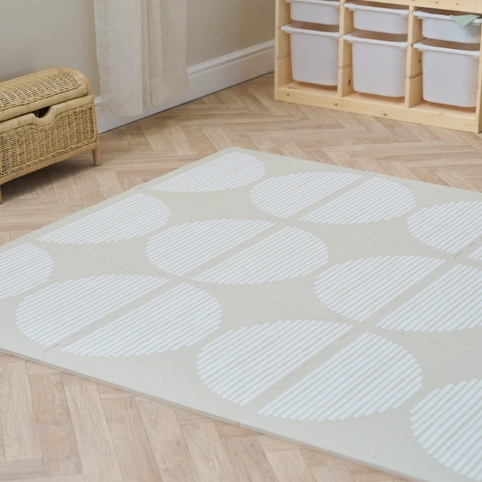 Infinity playmat Orbital Oatmeal on a neutral playroom.
