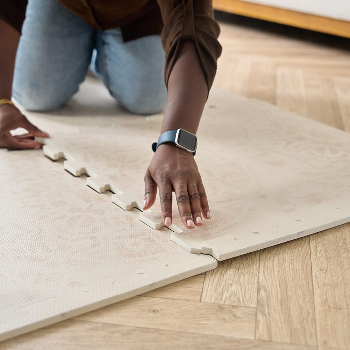 Detailed view of the Infinity Playmat edges with a hand connecting the pieces.