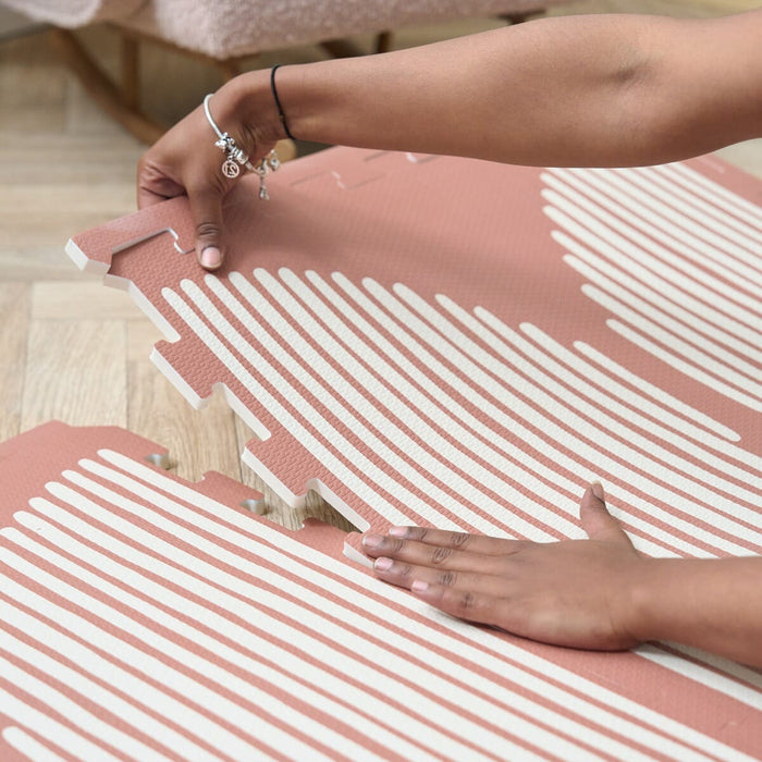 Detailed view of the Infinity Playmat Orbital Nutmeg edges with a hand connecting the pieces.