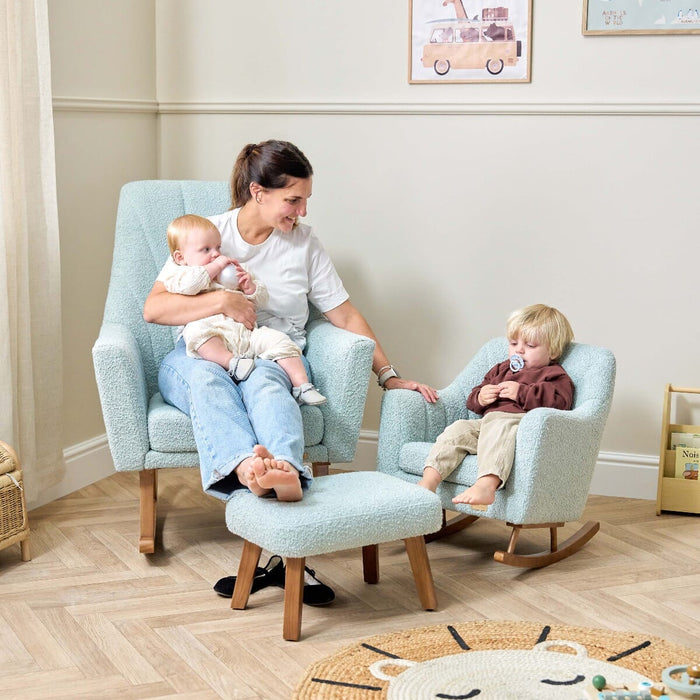 Mum and two children sitting on the Jonah rocking chair and mini rocking chair in Ocean Stone, showing the coordinating boucle fabric set