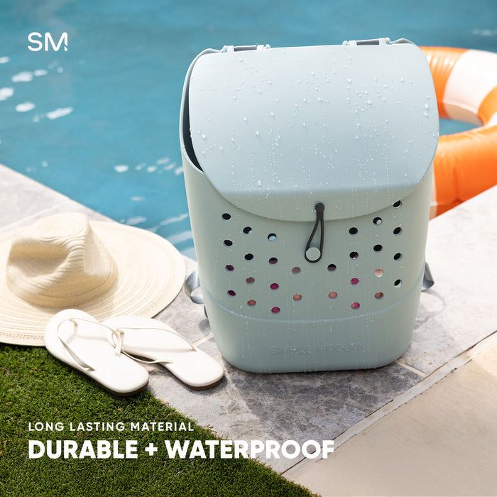 White insulated beverage container with water droplets displayed poolside next to a sun hat and sandals, with orange pool ring visible in turquoise water background. Text reads "Long Lasting Material" and "Durable +