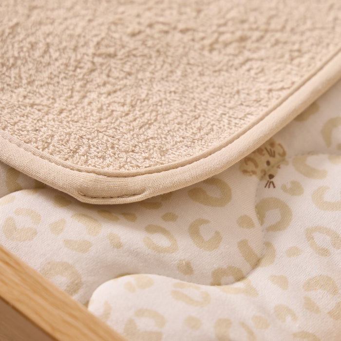Close-up of a textured beige mat and a patterned fabric with a wooden frame.