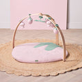 Strawberry muslin baby playmat with wooden playgym arch and soft hanging toys styled on woven rug.