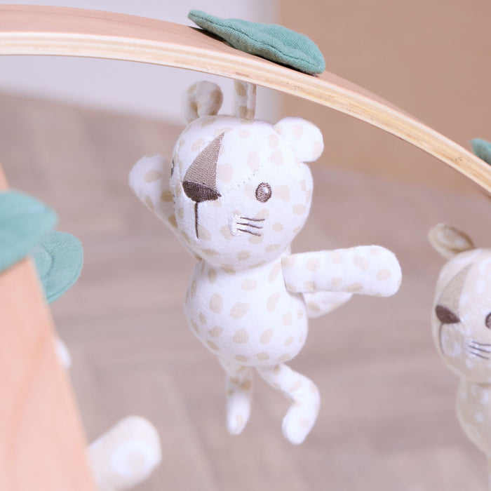 Close-up of spotted Love Cats character toy hanging from wooden play gym arch, crafted in soft muslin fabric.