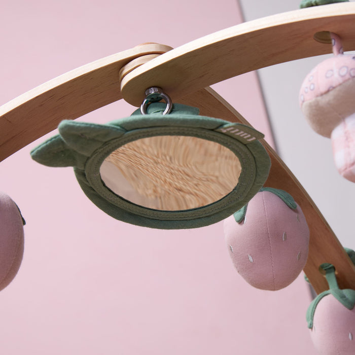 Close-up of hanging leaf-shaped baby-safe mirror attached to wooden playgym arch.