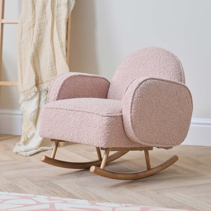 Angled view of Micah Mini Me Rocking Chair in boucle blush showing compact design and stable wooden rocking base.