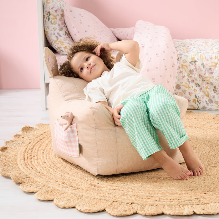 Toddler relaxing on the Milo Mouse beanbag chair in beige, showing comfortable seat shape and soft gingham details in a cosy room setting