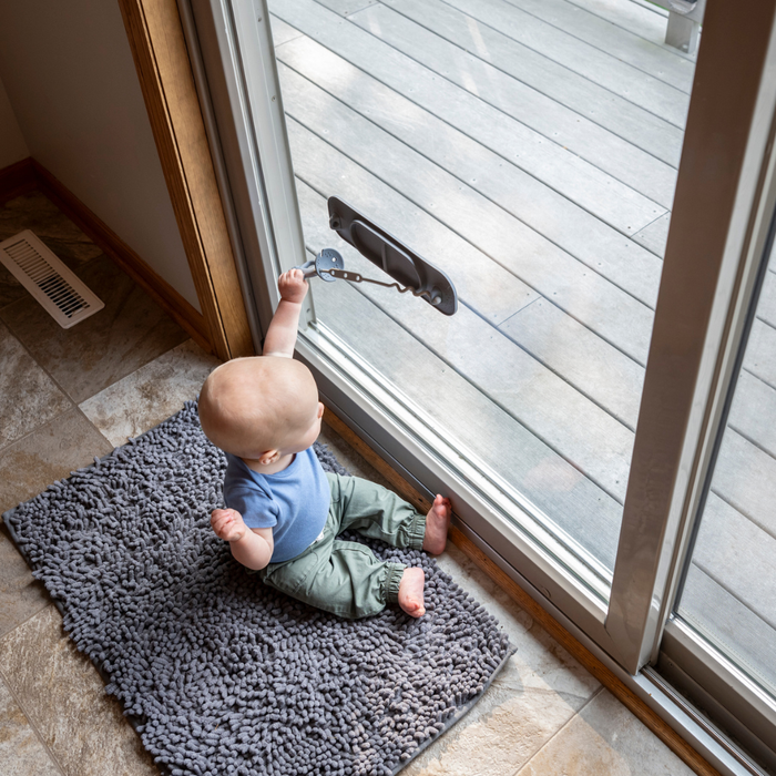 baby playing with busy baby mini silicone placemat on window