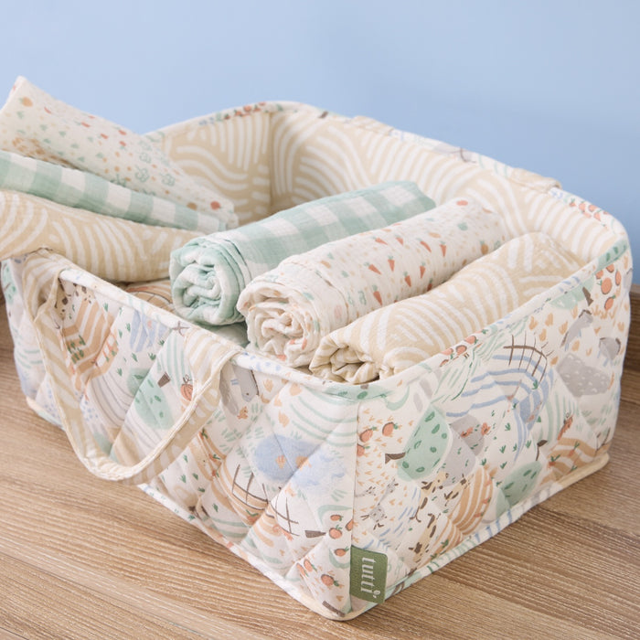 Good Life nappy caddy filled with soft rolled muslins in coordinating tones, showcasing quilted design and playful countryside print
